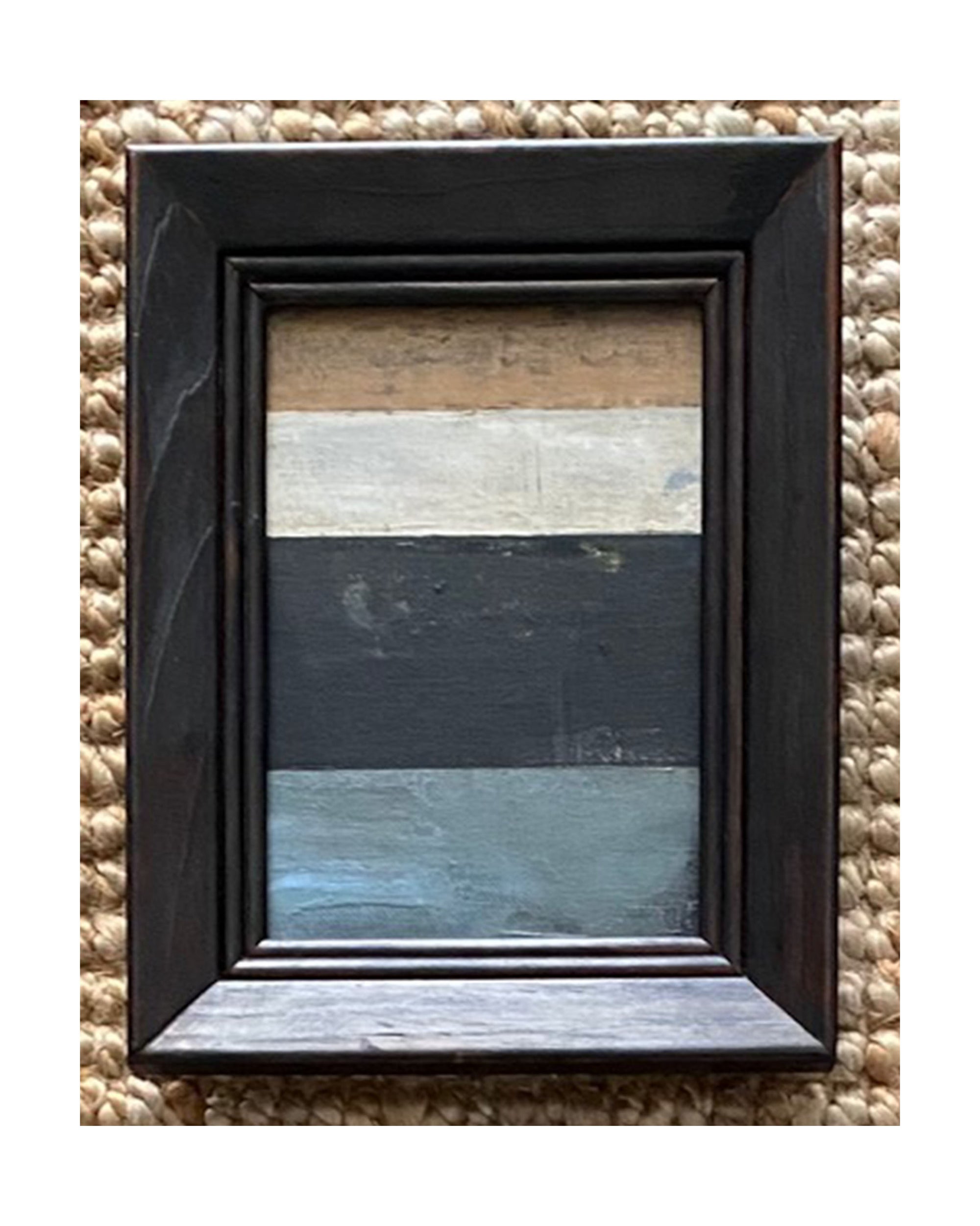 The STRIPES Framed Art by Tak Design features an abstract painting with beige, tan, off-white, black, and blue stripes in a small dark wooden vintage frame. Its woven background and hand-painted style add character to any space.