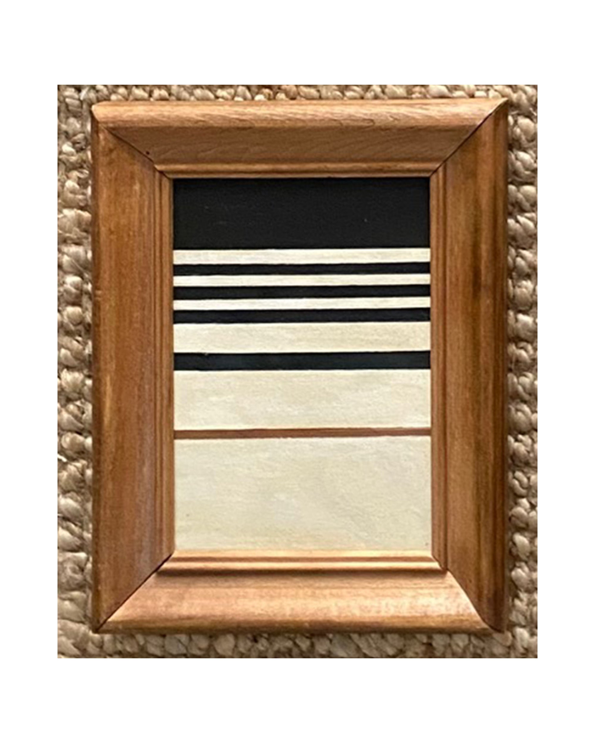 The STRIPES Framed Art by Tak Design is a small abstract painting with a wooden frame, featuring hand-painted black and white stripes above beige and white blocks separated by a thin brown line on a textured surface.