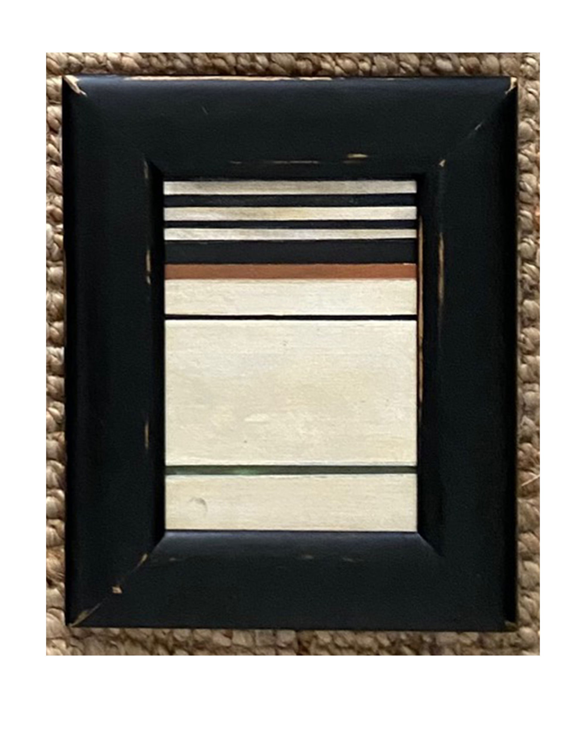 The STRIPES Framed Art by Tak Design features hand-painted black, white, beige, and tan horizontal stripes in a distressed black vintage frame, displayed on a woven textured background.