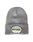 Faire Patch Beanie Strong as a Mother: gray knit plush with adjustable cuff, features a white oval patch with green "Strong as a Mother" text and EST. 2023.