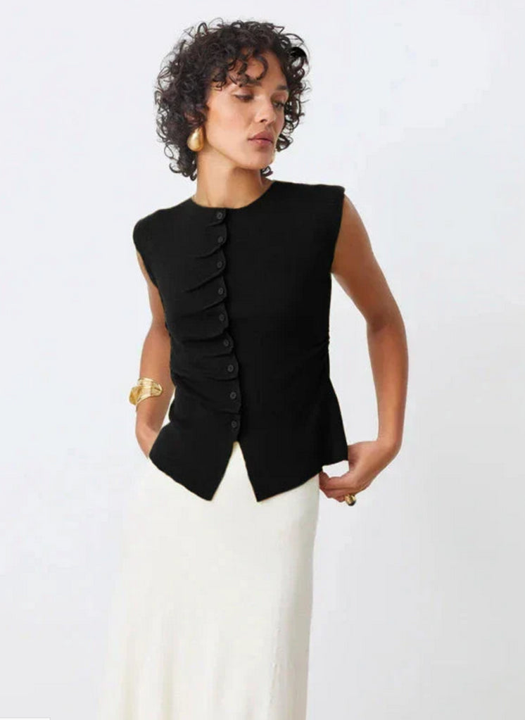 A woman wearing the SUNCOO PAGNI S/L button front top in black paired with a white skirt.