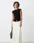 A woman wearing the SUNCOO PAGNI S/L button front black jumper over a white skirt.