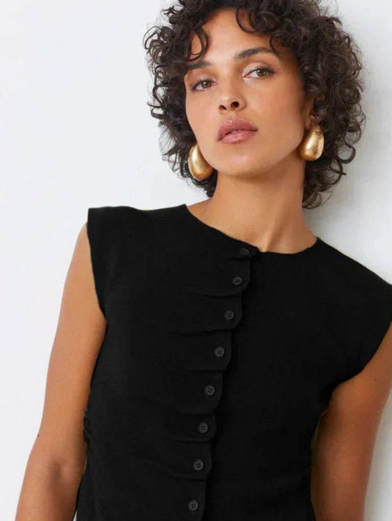 A woman in the SUNCOO PAGNI S/L button front black pleated jumper exudes effortless elegance.