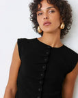 A woman in the SUNCOO PAGNI S/L button front black pleated jumper exudes effortless elegance.