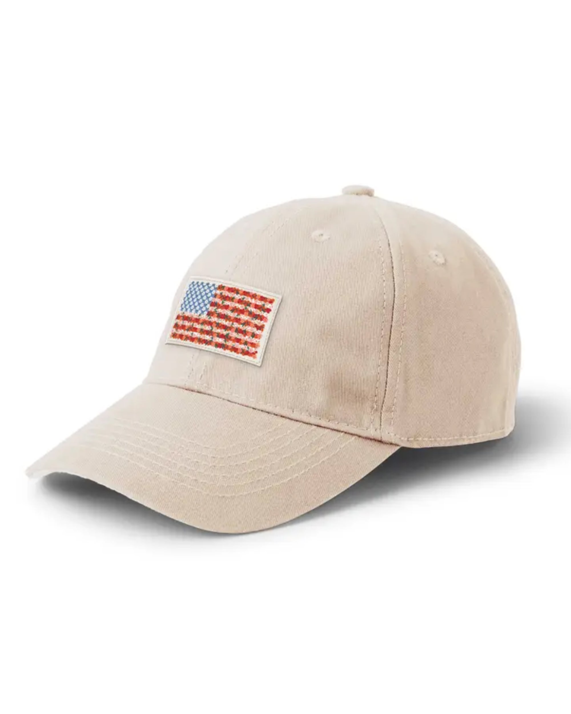 The Faire Americana Baseball Cap is beige with a small embroidered American flag patch on the front and features an adjustable strap for comfort.