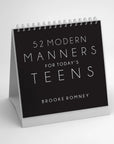 “52 Modern Manners” by Faire is a spiral-bound desk calendar designed to teach manners and social skills, featuring a minimalist black cover with white text.