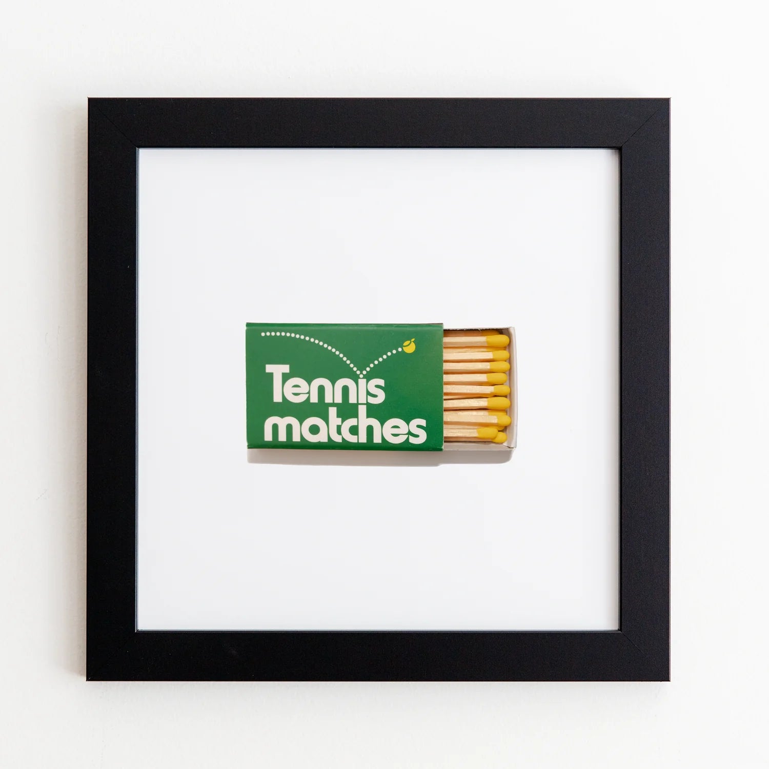 A book of green &quot;Tennis matches&quot; matches with some sticks visible is displayed in an Art Square Black Frame artwork on a white background by Match South.