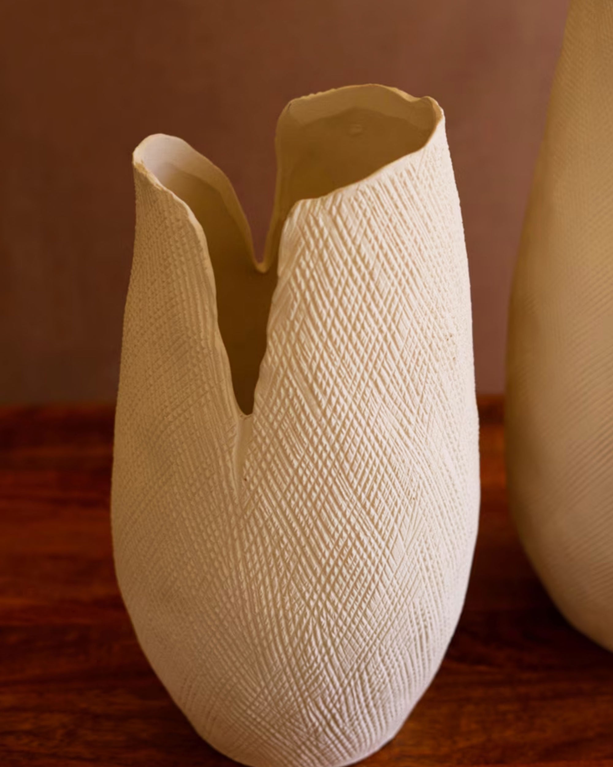 The Bloom Flower Vase S by Kalalou, Inc is a white textured vase with a cracked effect and jagged opening, displayed on a wooden surface against a neutral background.