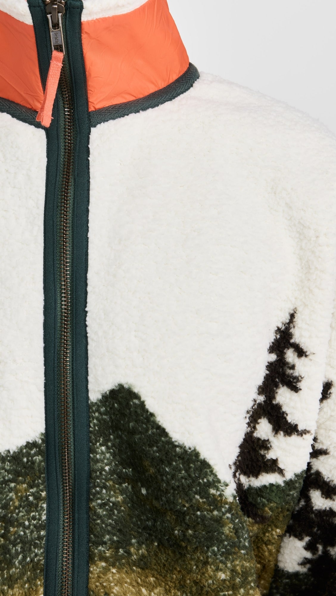 The Great Inc. Plush Terrain Full-Zip features a plush fleece build, zip front pockets, forest green zipper, green mountain and tree landscape pattern, and an orange collar with green trim and a zipper pull.