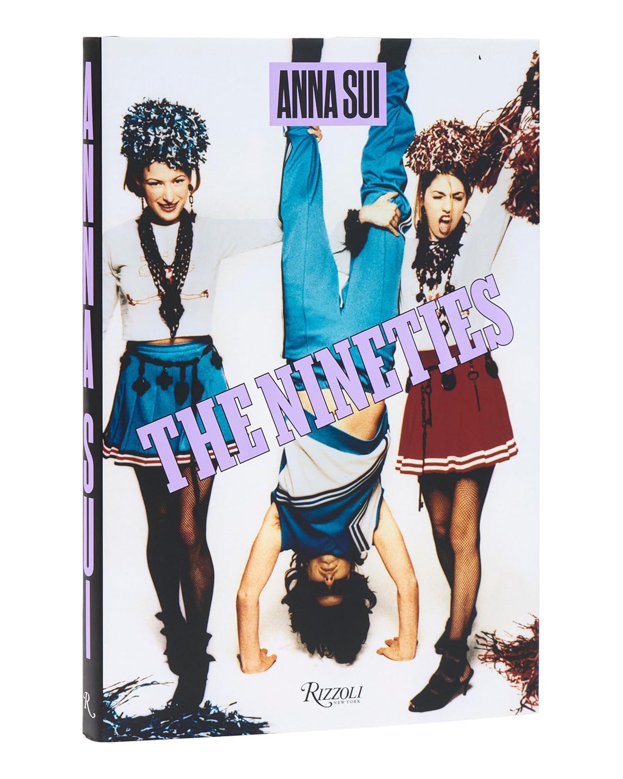 The book cover for "Nineties X Anna Sui" by Random House shows two girls in cheerleader outfits holding a third person upside down, with bold purple text and baby-doll dress details reflecting '90s fashion.