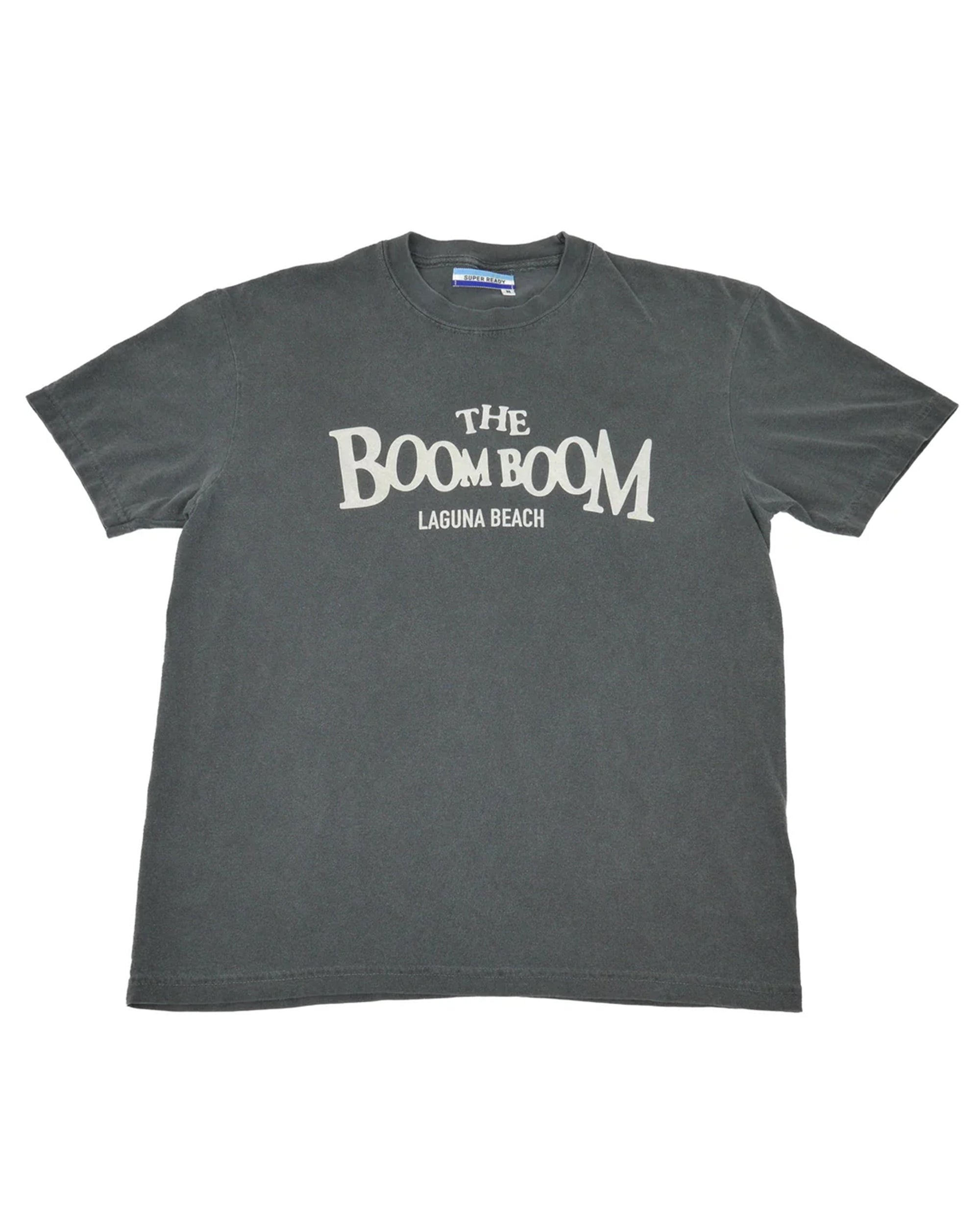 The Boom Boom by Hype Factory Inc.: a dark gray, vintage washed unisex short-sleeve tee made from 100% cotton with "THE BOOM BOOM LAGUNA BEACH" in bold white letters on the chest, laid flat on a white background.