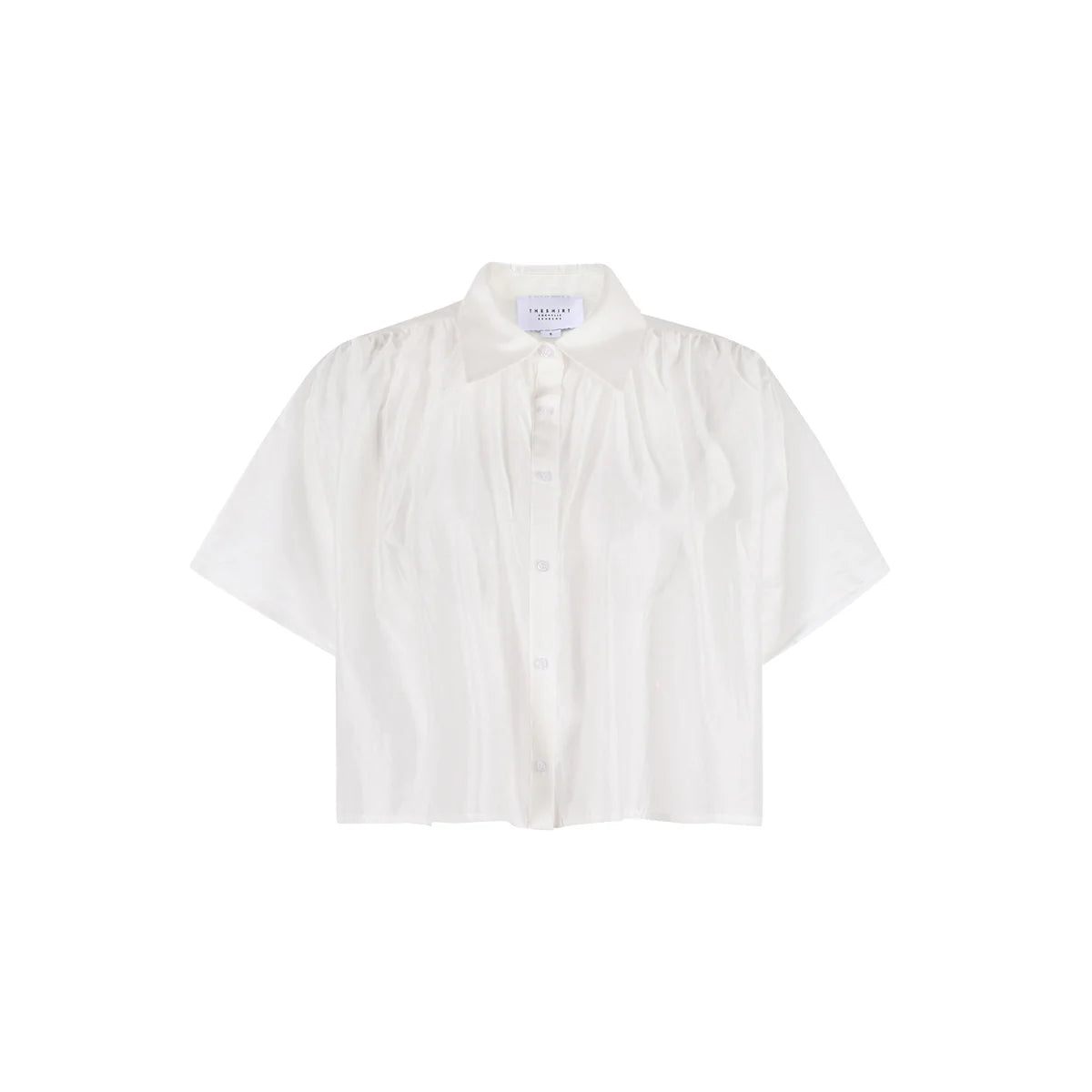 The Hayden Shirt by THE SHIRT is a short-sleeved, white cotton voile shirt with a collar and subtle front pleats, shown against a plain white background.