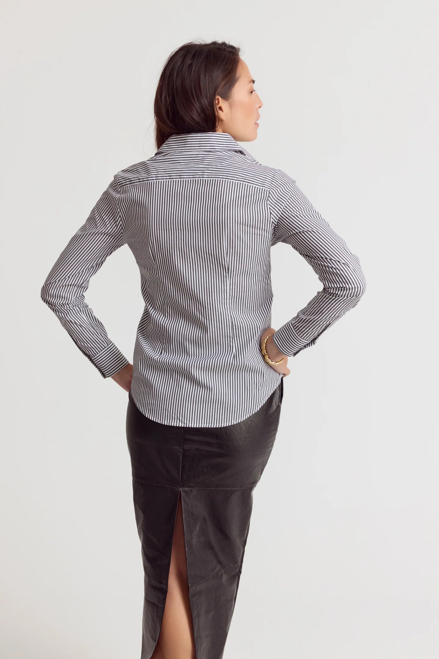 Striped Icon Shirt by THE SHIRT with no-gape buttons, styled with a black skirt, modern and polished look.