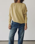 Wearing The Sweatshirt 26 by Hey Gang with blue jeans, a person stands against a plain white background. Their head is out of the frame and their arms are relaxed at their sides.