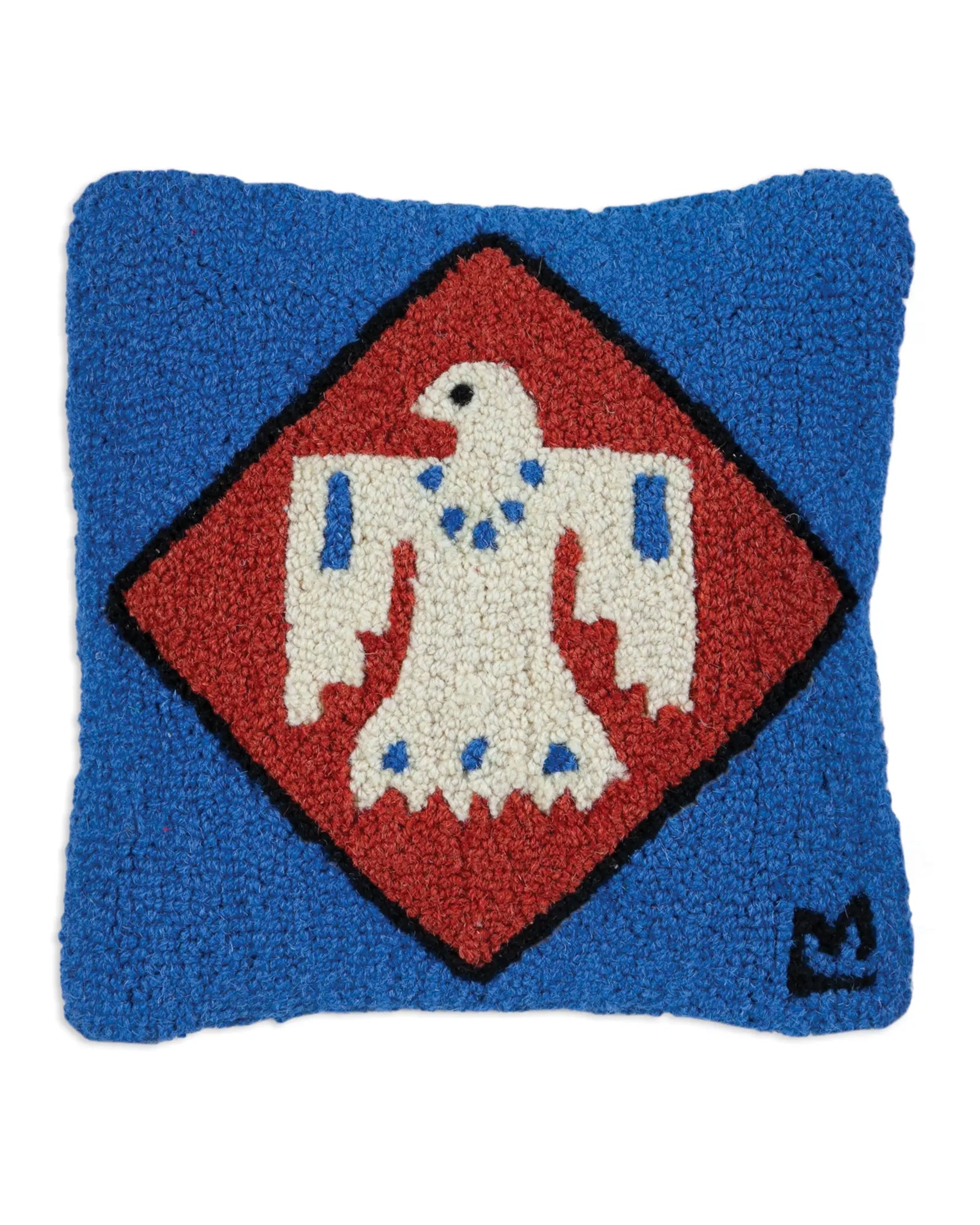 The Faire C4C Thunderbird Pillow is a square blue cushion with a hand-hooked texture, featuring a white bird with blue accents inside a red diamond bordered in black, plus a small black emblem in the lower right corner.