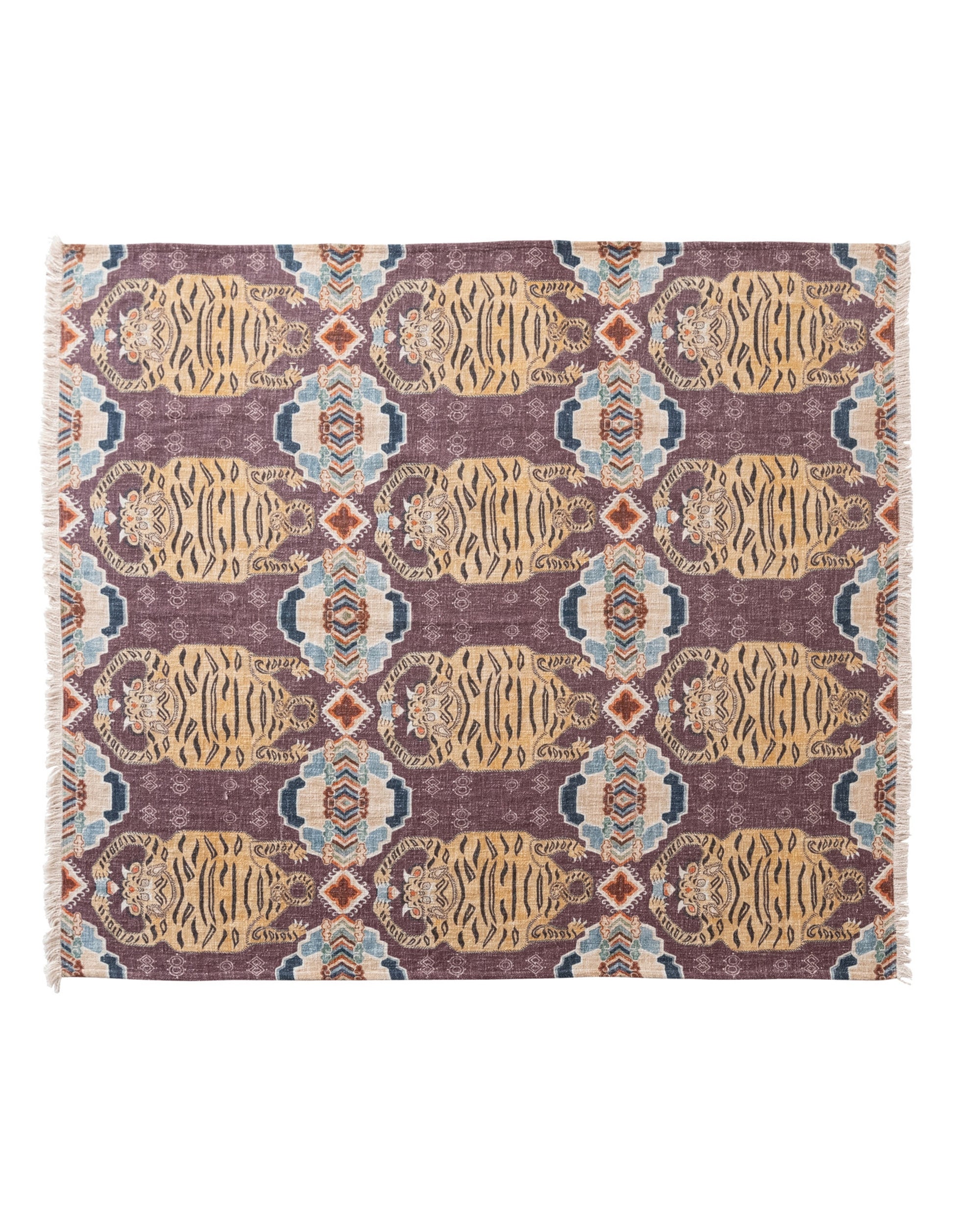 The Bloomingville Cotton Throw / Tibetan Tigers features a rectangular woven design with geometric and animal patterns in gold, purple, blue, and red. Fringed edges on the short sides add texture—ideal for boho decor.
