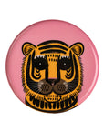 The Indaba Pink Tiger Tray features a round pink design with a stylized yellow, black, and brown tiger face. Bold stripes and cartoon-like symmetry make it a whimsical enameled accent decor or serving tray.