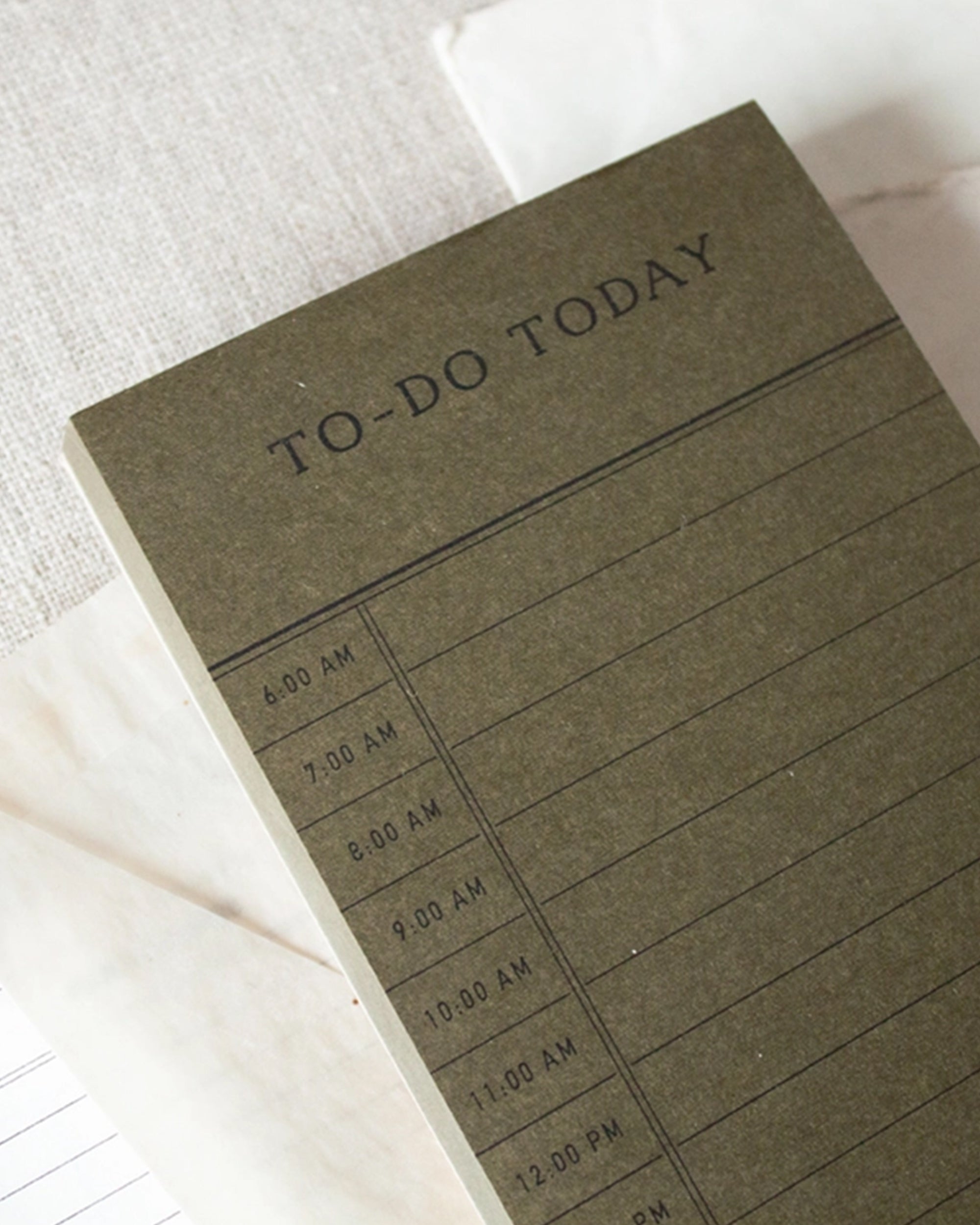 The Faire To Do Today Planner is a green notepad with "TO-DO TODAY" and time slots from 6:00 AM to 12:00 PM. With 50 sheets, it’s perfect for hourly planning and fits neatly on your desk.