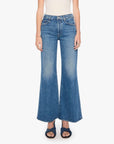 The Tomcat Roller Sneak jeans by Mother styled with a white top and black sandals for a vintage denim look.