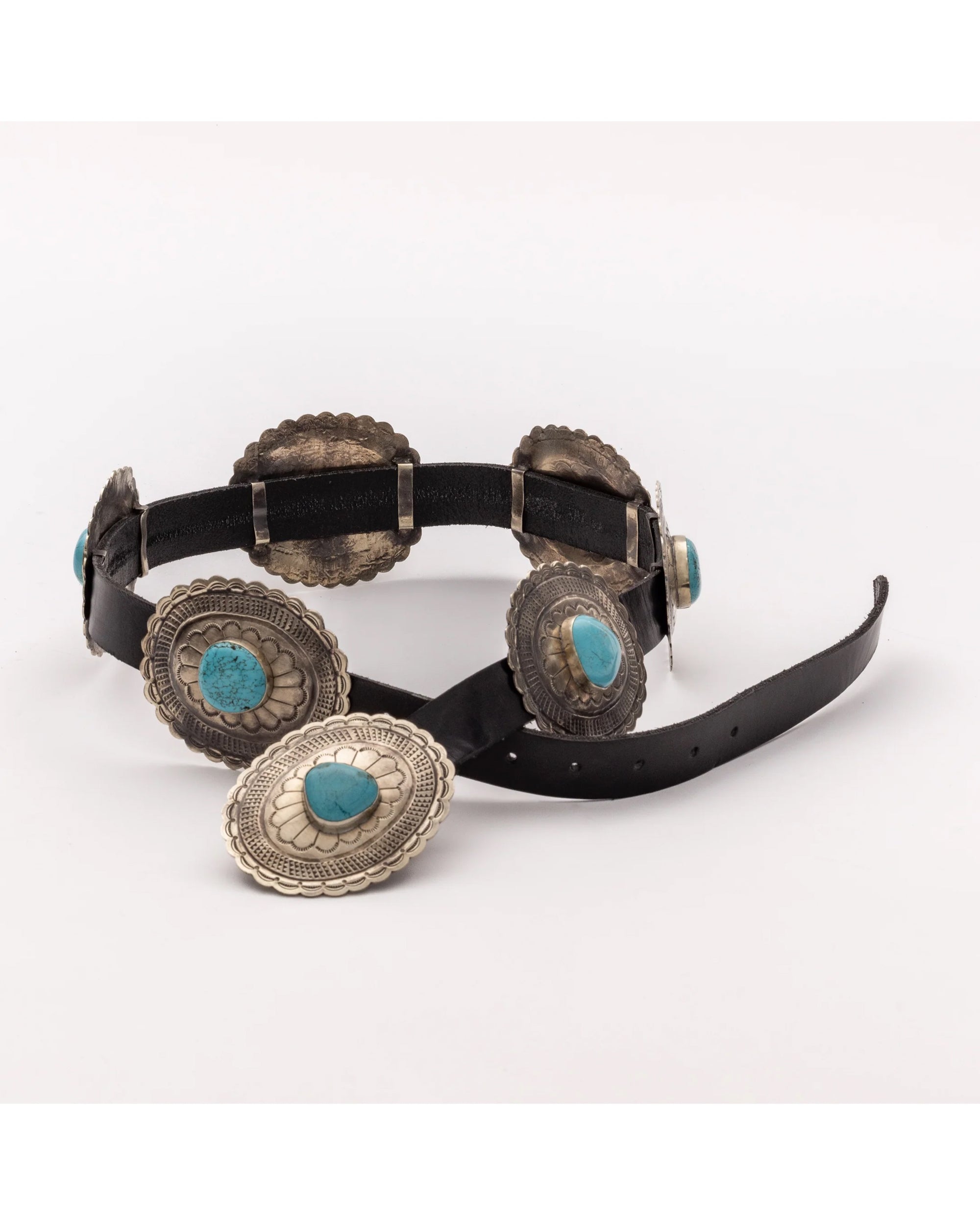The J Alexander Rustic Silver Concho Belt Oval is a black leather belt with large oval silver conchos, each featuring intricate designs and turquoise center stones, shown on a white background.