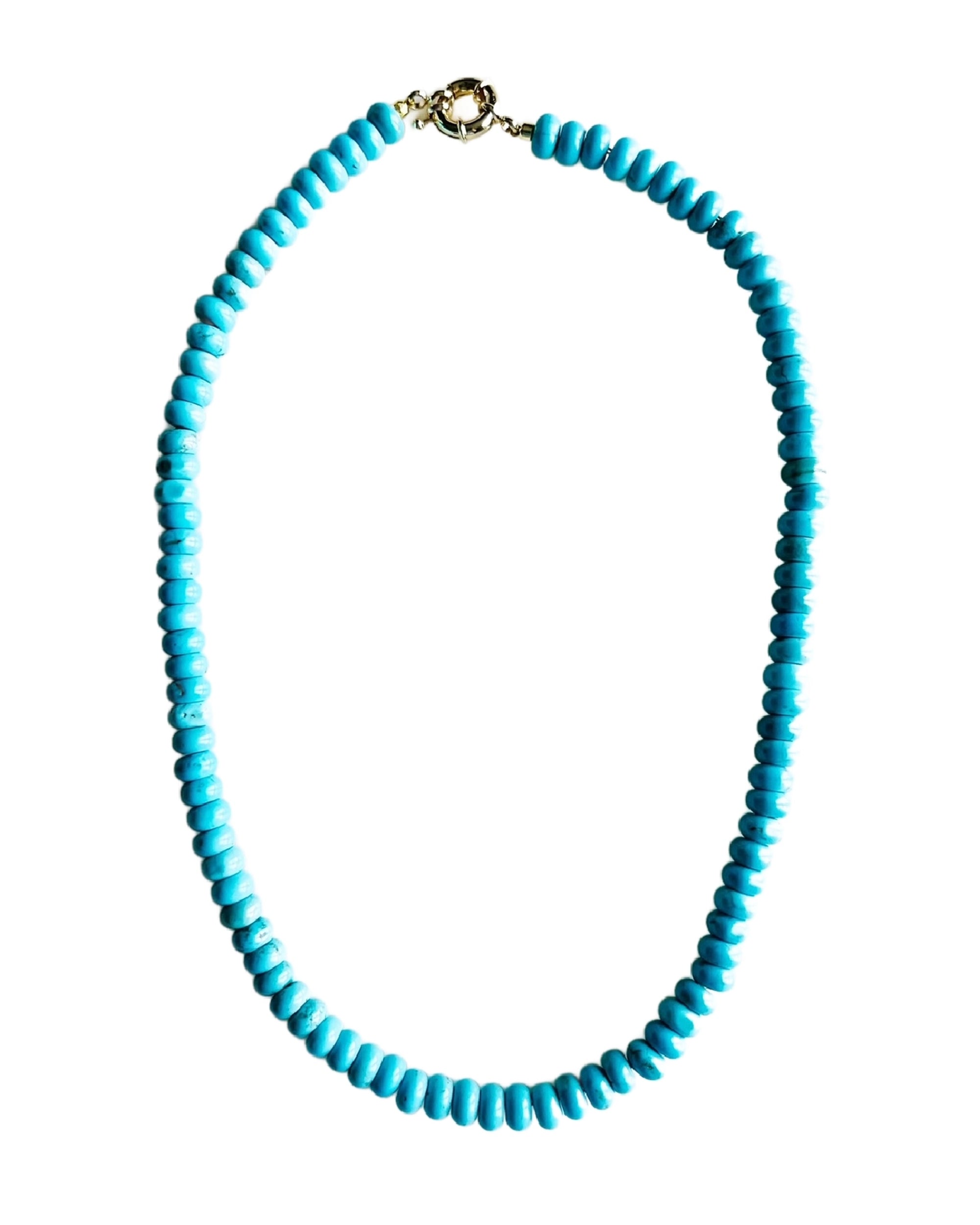 The Faire Turquoise Howlite Candy Necklace features round, bright turquoise beads evenly strung and finished with an 18kt gold plated clasp, beautifully displayed against a white background.