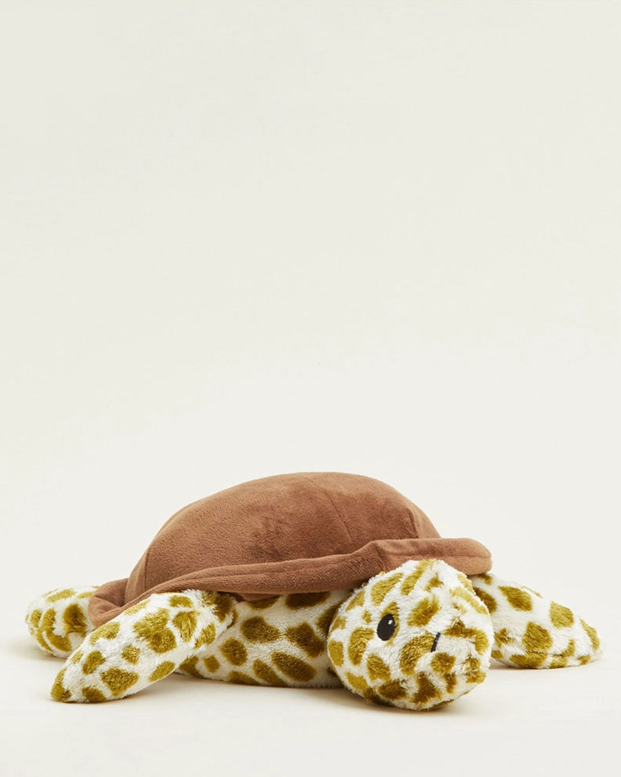 The Turtle Warmies by Faire is a plush toy with a brown shell and soft, patterned yellow and white flippers and head, offering sensory comfort against a plain light background.