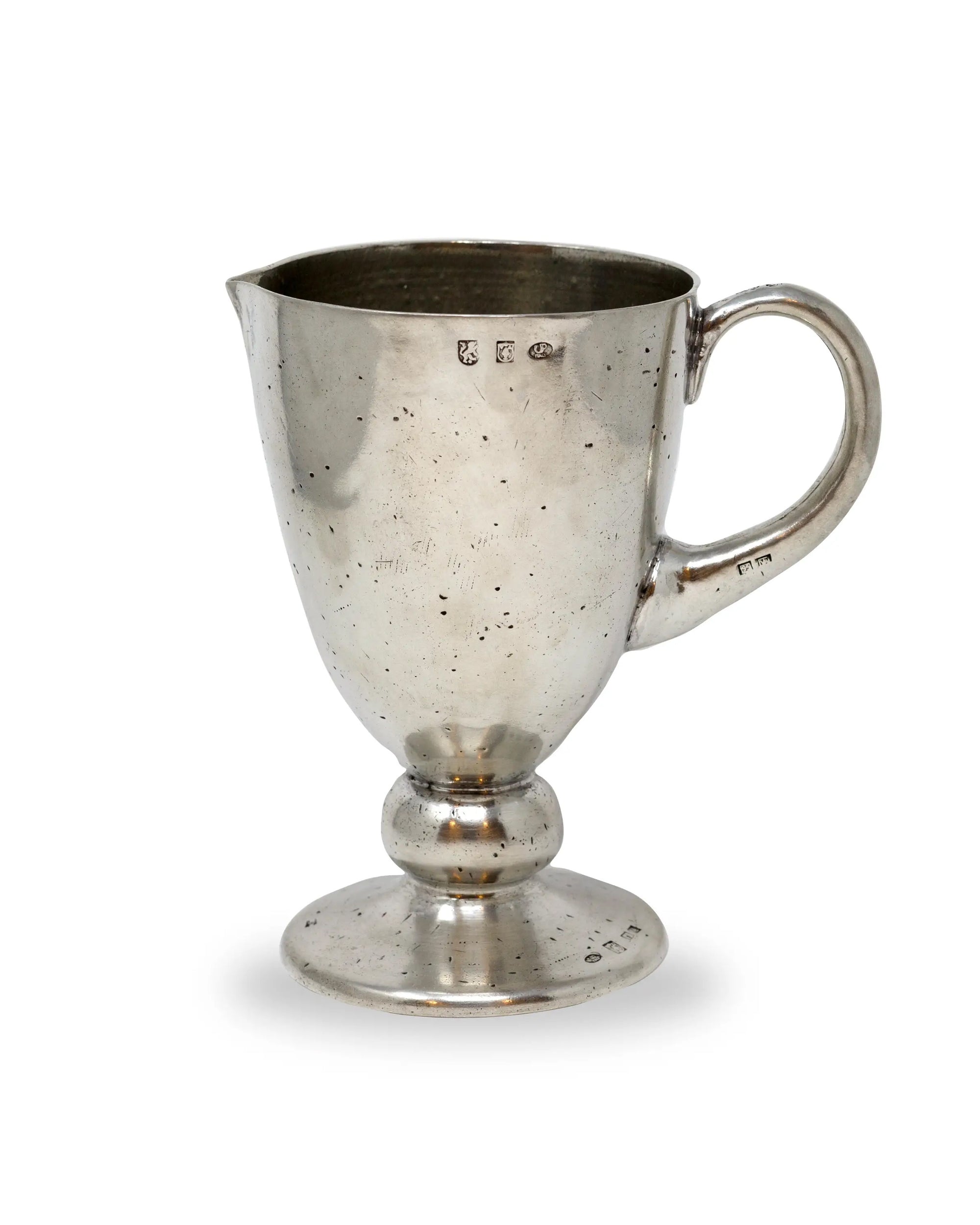 The Faire PEL1871 Veneto Pitcher is a vintage pewter piece with a handle, spout, and rounded pedestal base. It features some tarnish, small hallmarks near the top, and is photographed on a plain white background.