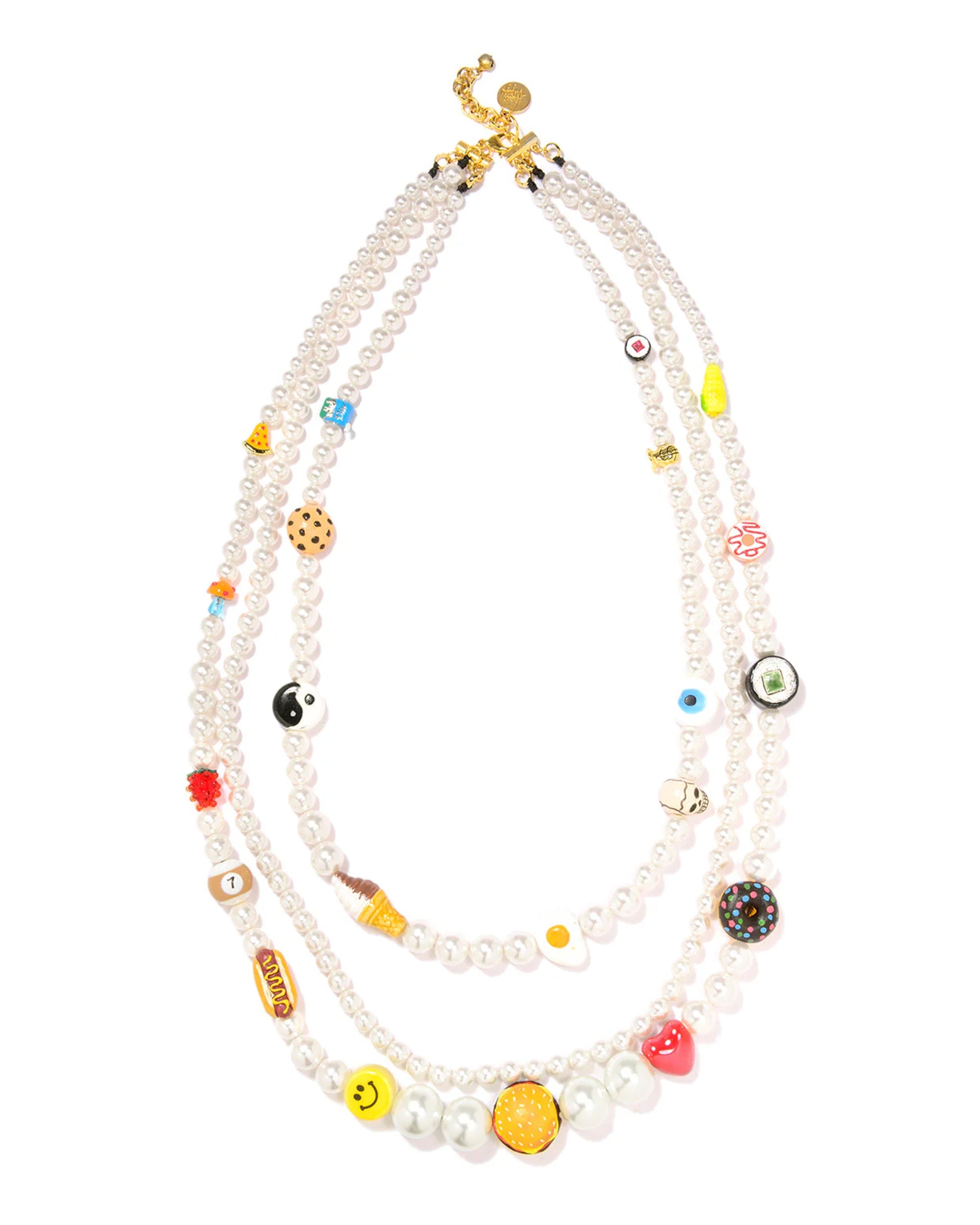 The Venessa Arizaga Vibe Check Necklace 30-38" features three crystal pearl strands with gold clasps, each adorned with colorful beads in playful food, emoji, and symbol shapes—perfect for adding a whimsical touch to any look.