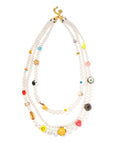 The Venessa Arizaga Vibe Check Necklace 30-38" features three crystal pearl strands with gold clasps, each adorned with colorful beads in playful food, emoji, and symbol shapes—perfect for adding a whimsical touch to any look.