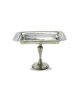 The Faire Vintage Rec Pedestal Dish, crafted in Italy from fine pewter, features a raised edge and slender stem on a round base, elegantly showcased against a white background.
