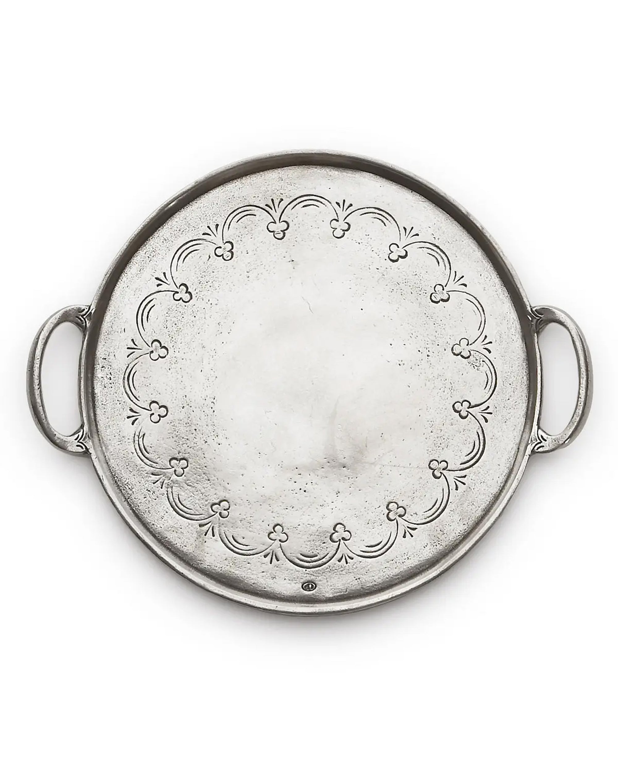 The Vintage Pewter Round Tray With Handles by Faire features a decorative floral-etched inner rim, two side handles, a round shape, and a subtly textured silver finish. Handmade in Italy.