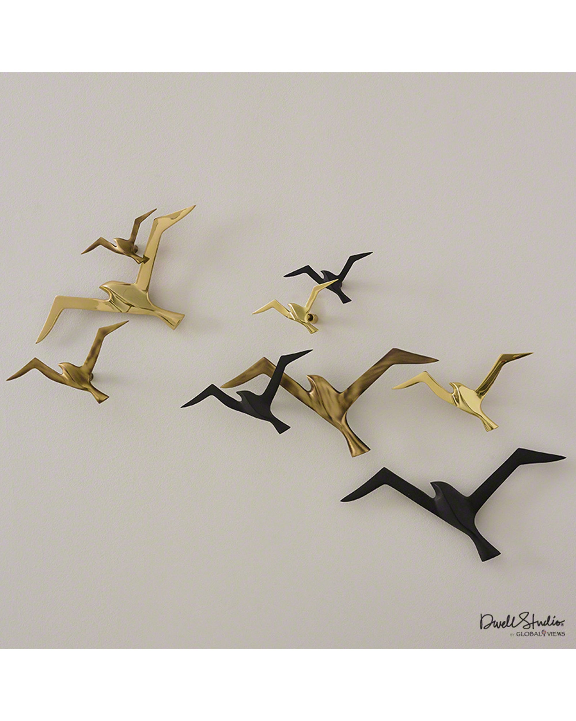 The Metallic Flock Black by Global Views features matte black and gold wall-mounted metal birds, forming a modern flock decor—an elegant accent for art galleries or stylish spaces against any light backdrop.