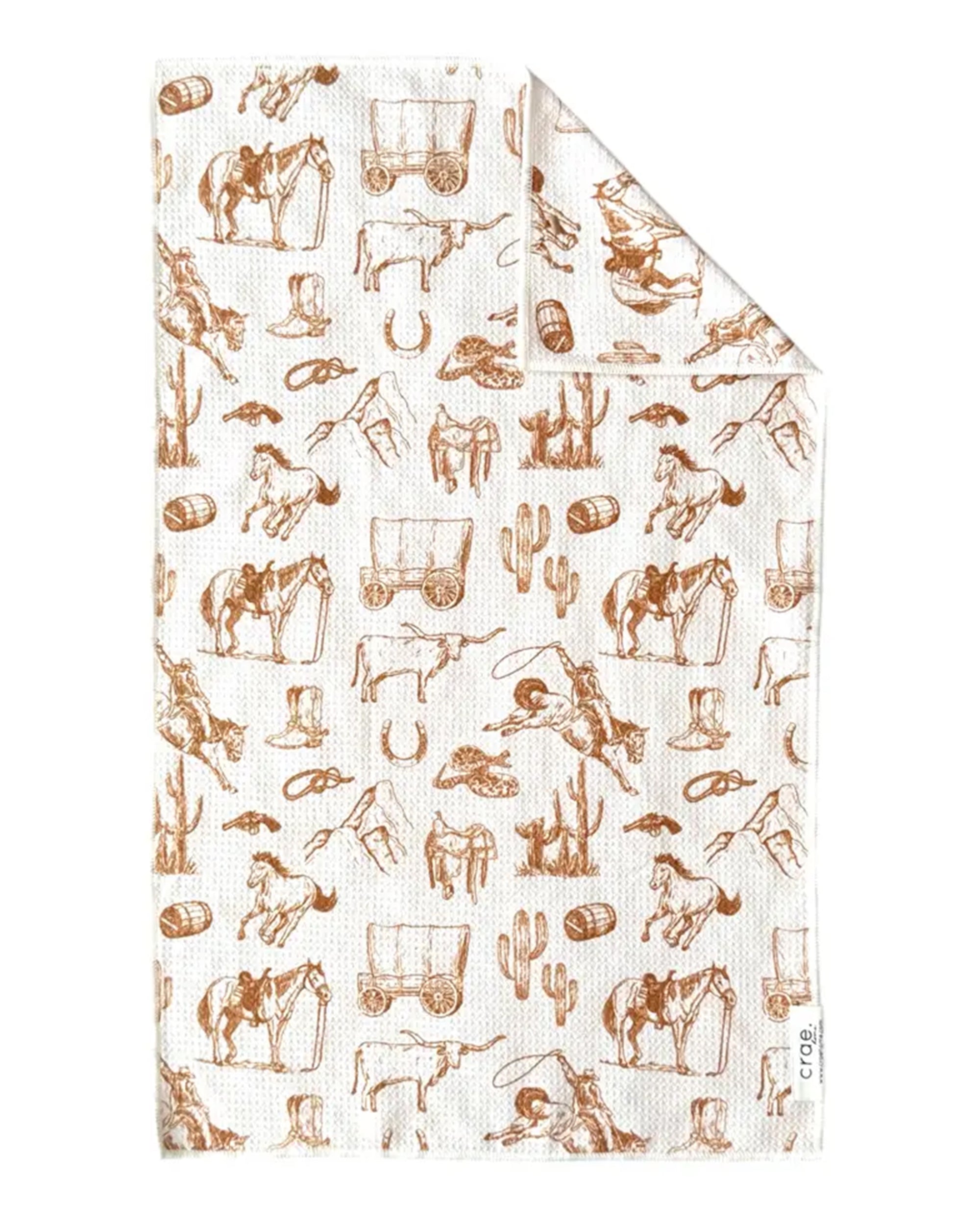 The Faire Hand Towel: Western is a white waffle weave microfiber towel with brown line drawings of cowboy hats, horses, cacti, lassos, boots, wagons, cattle, and horseshoes in a repeating Western-themed pattern.
