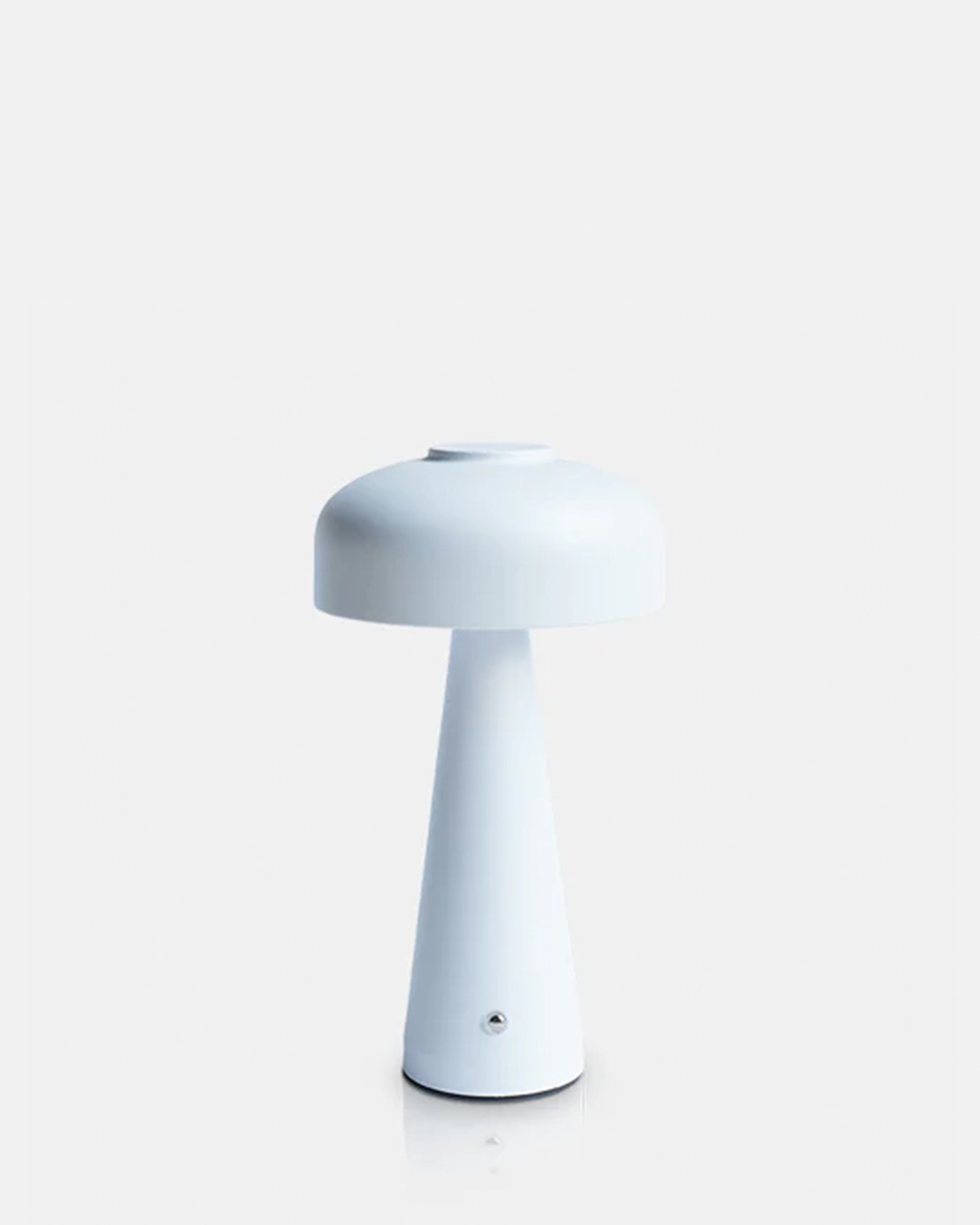The Abigail Ahern T3-001 Adelaide LED Lamp is a modern, minimalist white dimmable portable light featuring a round mushroom-shaped shade and conical base, shown against a plain light gray background.