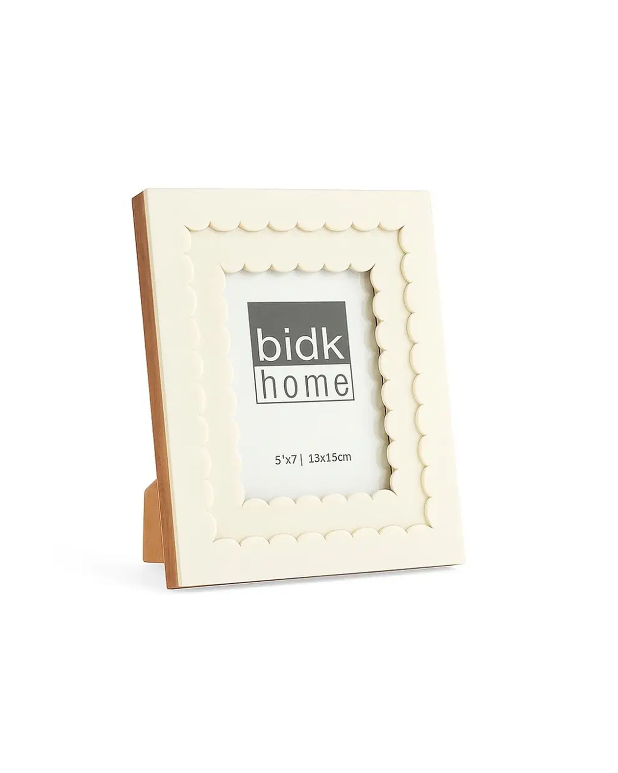 The 705140 5x7 Floral Resin Frame by BIDK Home features scalloped edges, an elegant white design, and stands on a wooden easel back. Fits a 5&quot;x7&quot; photo—ideal for displaying cherished memories and enhancing your home decor.