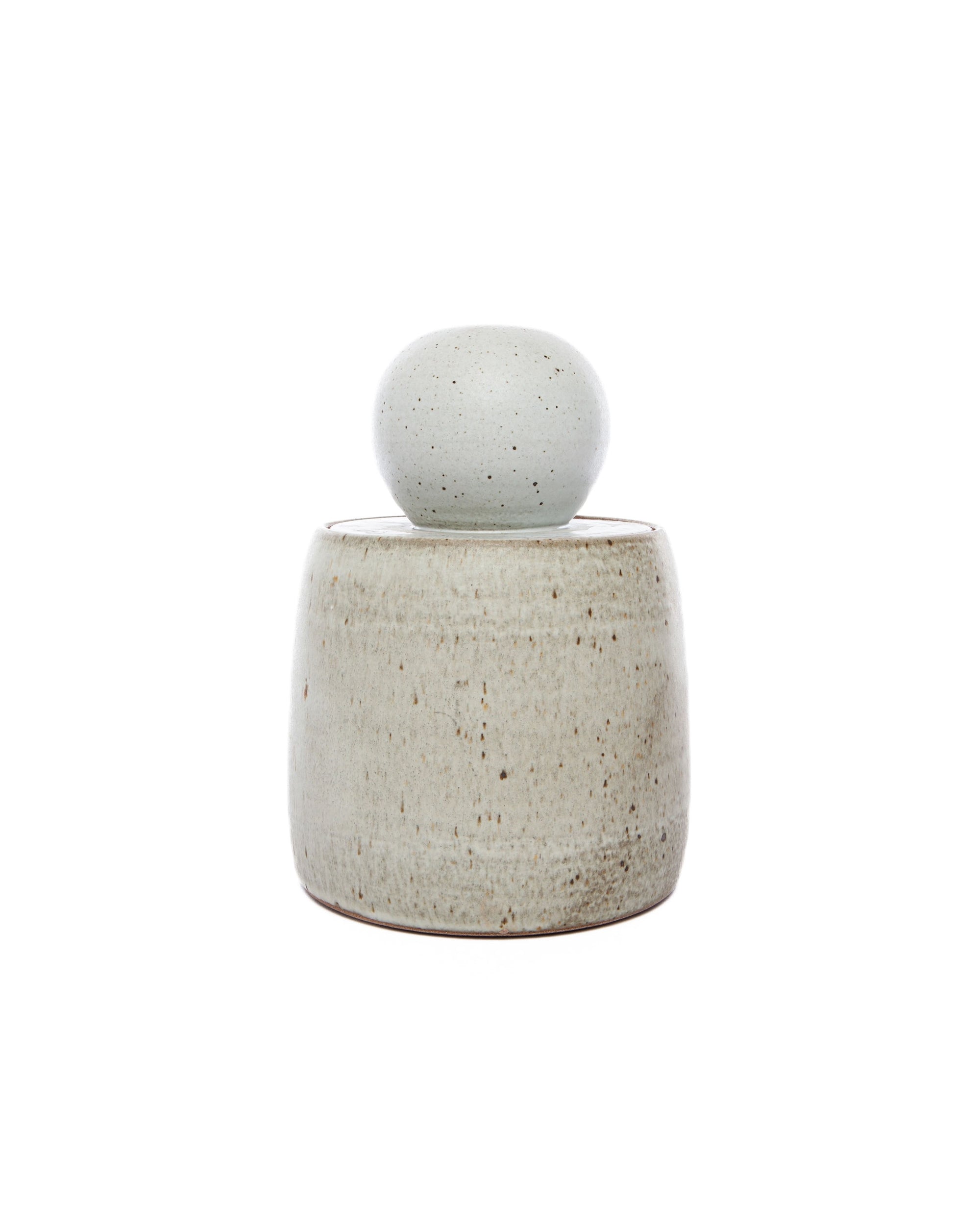 The Faire Alabaster White Stash Jar features a minimalist, speckled light gray stoneware body with a matching domed lid, matte glaze finish, and is displayed against a plain white background.