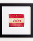 A vintage Winston cigarette pack, prominently red and white, is displayed within a Match South Art Square Black Frame on a white wall. The pack is labeled "Filter Tipped.