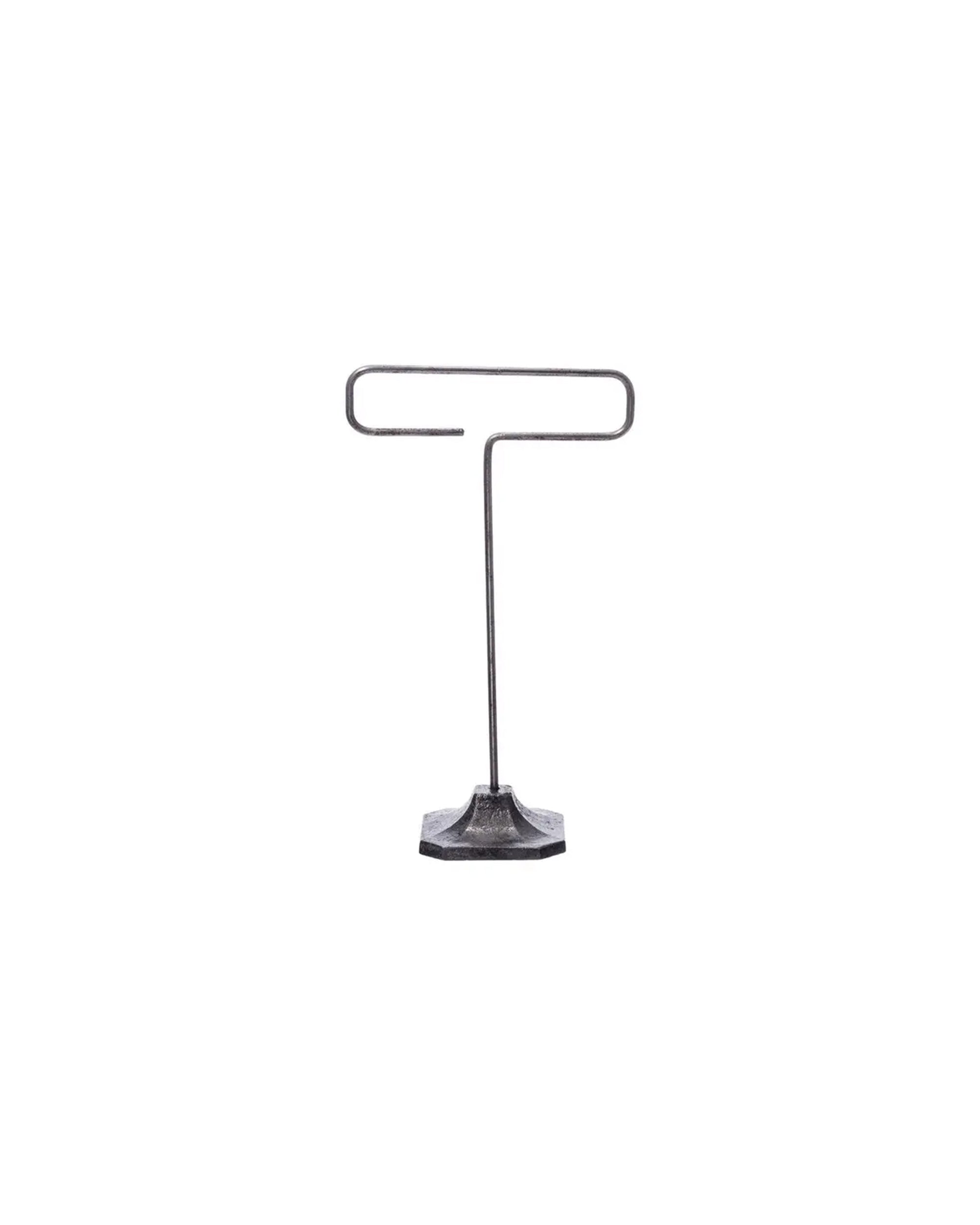 The Desk Wire Display Stand S by Faire features a hexagonal base and minimalist design, crafted from reclaimed steel wire to hold cards or small signs upright with a functional top loop.