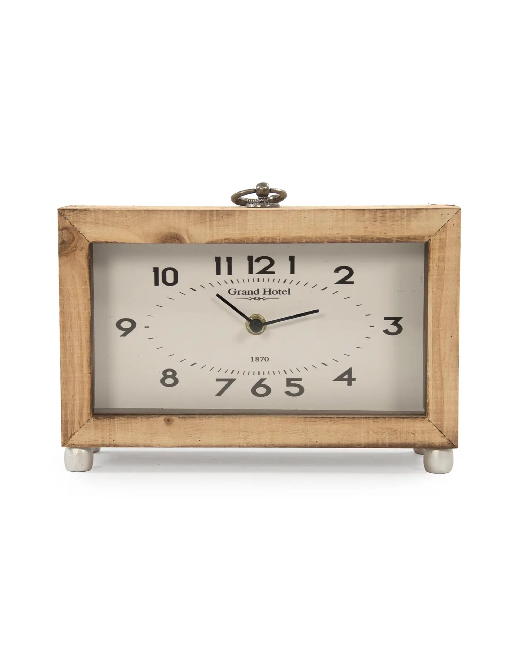 The Zentique PC077 Wooden Clock features a rectangular wooden design, white face with black Arabic numerals and hands, "Grand Hotel" text above the center, and stands on four small silver knob legs.