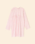 Introducing the Flora Dress by Xirena: a mini shirtdress featuring pink and white vertical stripes. Crafted from 100% cotton, it includes long sleeves, a yoke with horizontal stripes, and a gathered section below against a plain beige background.