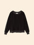 The Xirena Hopper Sweatshirt is a black long-sleeve pullover with a crew neck, ribbed cuffs and hem, made from a soft cotton blend velour, shown against a neutral beige background.