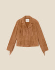 The Bronco Jacket by Xirena is a tan western fringe jacket with chest, sleeve, and pocket detailing. Made from goat suede, it features a notched collar and button-up front, displayed on a light beige background for a statement look.