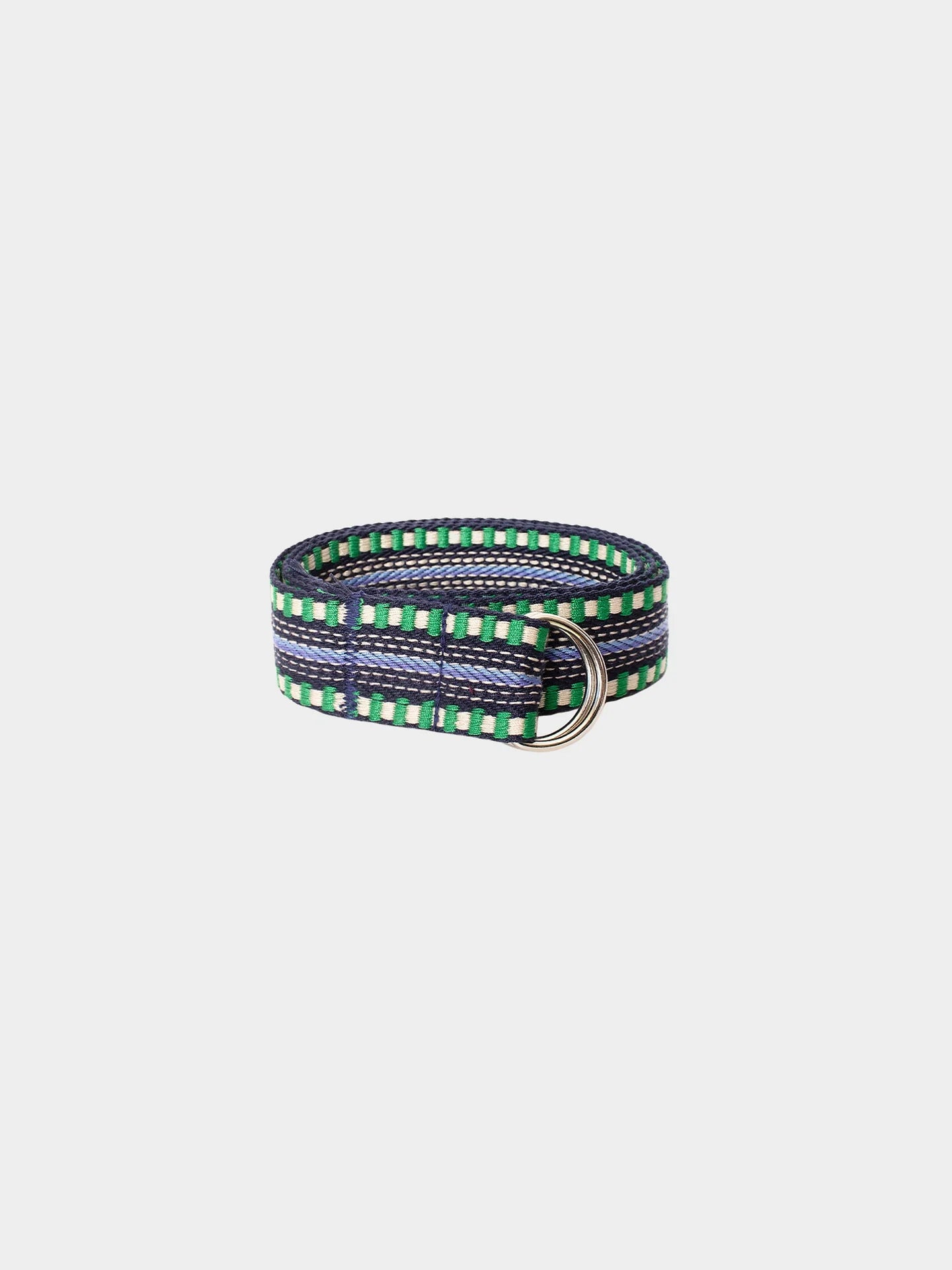 The Xirena Stevie Belt is a vintage-inspired accessory with green, white, and navy stripes, textured fabric, and two silver-tone D-ring buckles, shown on a plain light background.