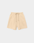 The Rocco Short by Xirena features vintage washed beige French terry, an elastic waistband with drawstring, two side pockets, and a relaxed fit. Made in Los Angeles and shown on a plain light gray background.