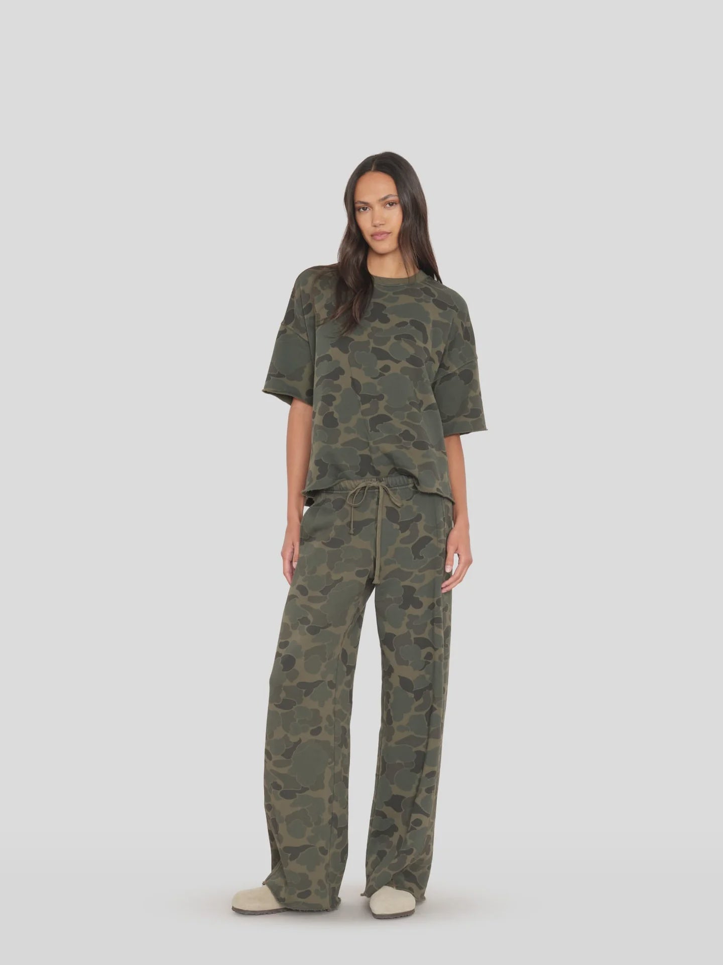 Renzo Sweatpant by Xirena styled with a loose green tee, casual look against a plain backdrop. Made in Los Angeles.