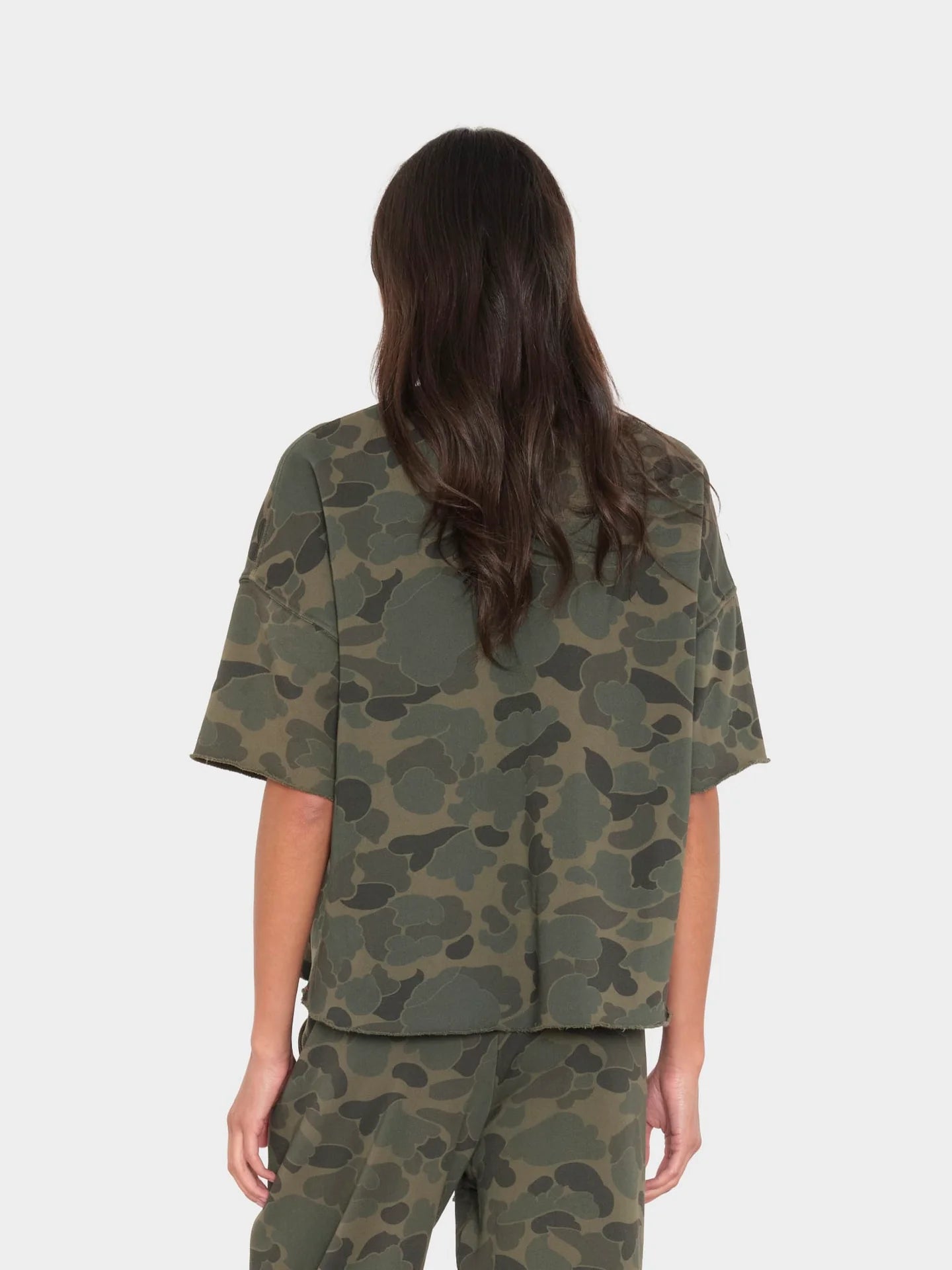 Back view of Xirena Romeo Tee in brown, modeled with long hair against a white background.