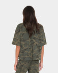 Back view of Xirena Romeo Tee in brown, modeled with long hair against a white background.