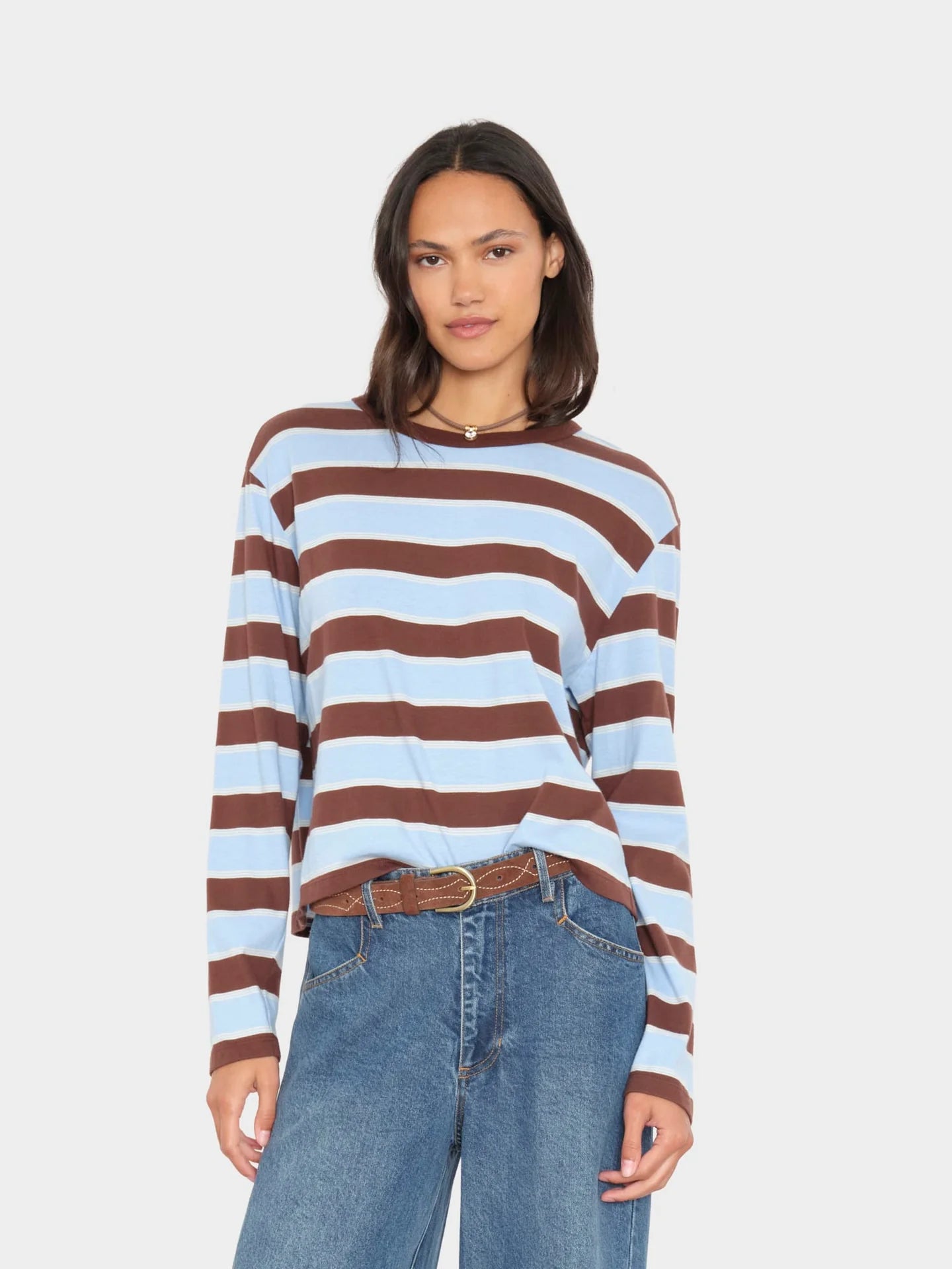 Xirena Terrance Tee in vintage-inspired striped cotton, boxy fit, styled with blue jeans and a brown belt.