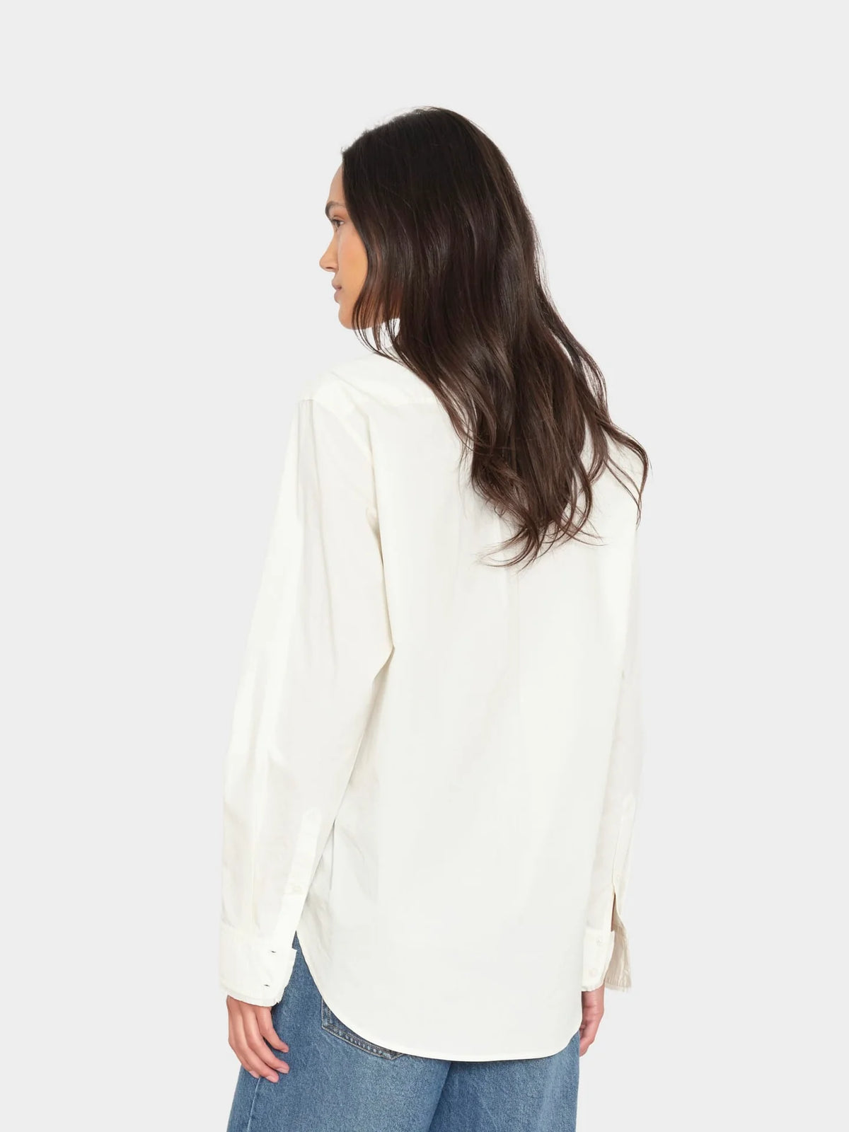 Xirena Beau Shirt in white and blue jeans, shown from the back on a woman with long brown hair.