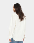 Xirena Beau Shirt in white and blue jeans, shown from the back on a woman with long brown hair.